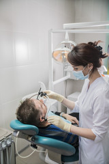 Obraz na płótnie Canvas dentist doctor puts on the patient dental front arc