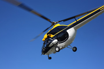 Fototapeta na wymiar Aircraft - Black-yellow helicopter flight at low height