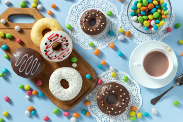 Delicious donuts with chocolate, coconut and strawberry. Served on the wooden board and white...