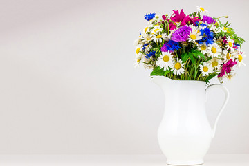 Wildflowers in white ceramic jug.