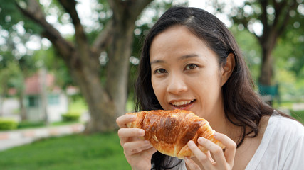 Asian woman mature adult eating bread carbohydrates