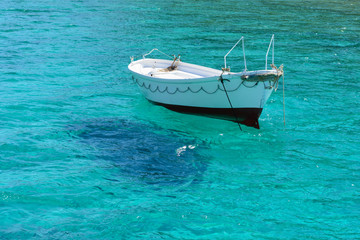 Fototapeta na wymiar White boat in sea waters near island