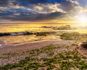 sea shore with stones after the storm at sunset