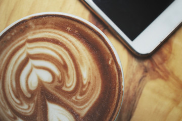 Vintage latte art coffee with smart phone