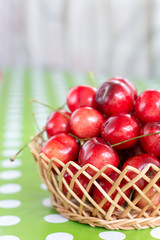 Shallow depth cherries in the basket blurred background