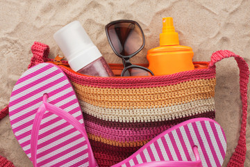 Bag with beach accessories lying on the sand of the beach
