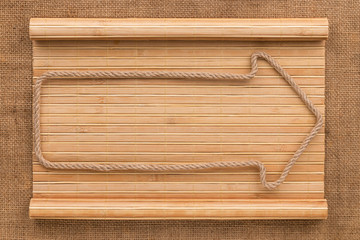 Arrow made of rope lying on a bamboo mat in the form of a manuscript