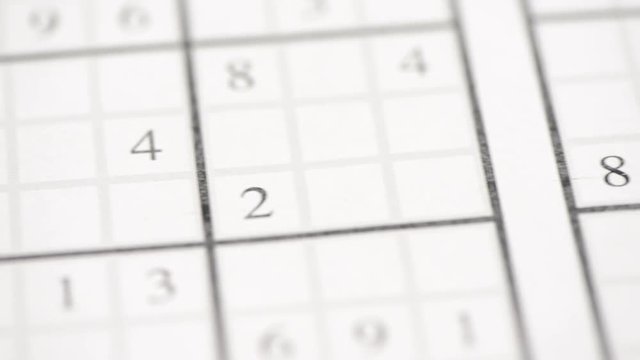 Sudoku puzzle and pen in close-up. Film clip with slow sliding motion. Concept of problem solving, leisure and mathematics.