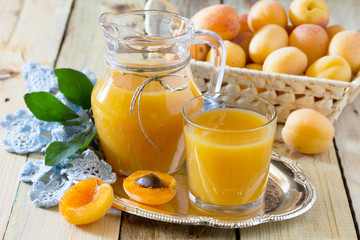 The refreshing summer drink with peach in a jug and glasses on a