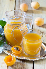 The refreshing summer drink with peach in a jug and glasses on a