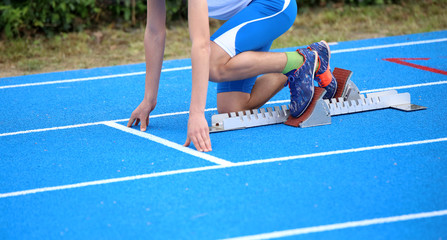 athlete in the starting blocks of a athletic track before the st