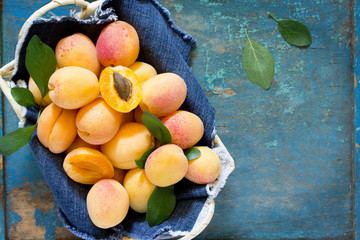 Harvest fresh ripe peaches in a wicker basket on old wooden tabl