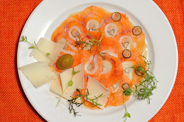 image of raw and fresh salmon sliced topped on ice in dish.