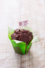 Chocolate muffin for party or birthday on a wooden background with copy space.