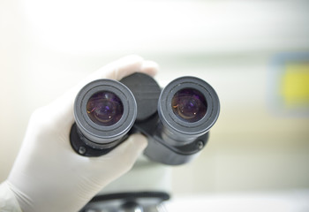 close-up of scientist hands with microscope, examining samples a