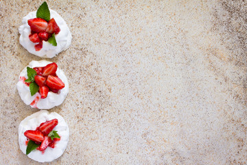 Pavlova meringue cake with fresh strawberries on brown stone bac