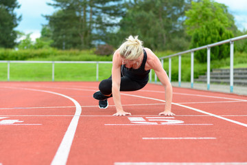 Fototapeta premium Athletic woman warming up hip muscles at track