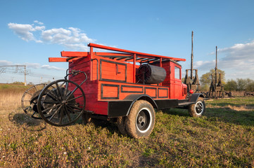 Back side old retro fire truck with wooden case on the field