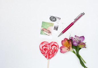 Composition with makeup cosmetics, pen, card and flowers on white background