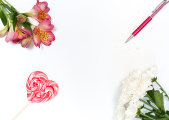 Composition with makeup cosmetics, pen, card and flowers on white background