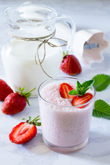 Fresh summer drink smoothies with strawberries on a gray stone b