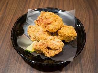 Fresh fried chicken on black plate set on wood table