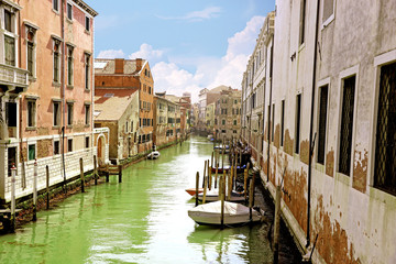 Fototapeta na wymiar Small venetian canal and old brick walls with vintage traditional balconies. Venice, Italy