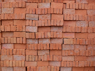 Bricks made from clay and burnt  arranged neatly for easy counting before transport to be used in construction.