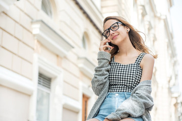 Young woman talking on the phone in the street .