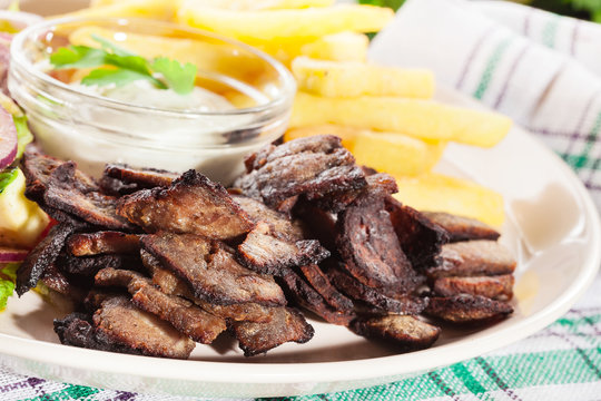 Grilled meat with French fries and fresh vegetables