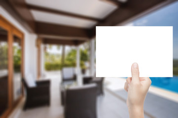 hand holding blank paper with interior background