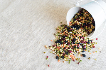 Grains and broad beans on white burlap 