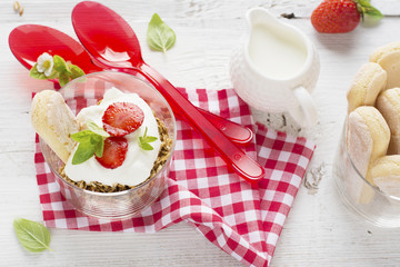 strawberry yogurt with muesli on a old wooden background