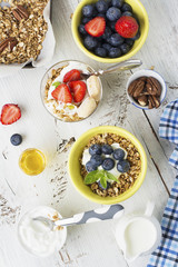 Healthy breakfast Fresh granola, muesli in bowl with milk and berries on a white background