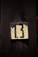 The board with the number thirteen on the wall of a wooden house