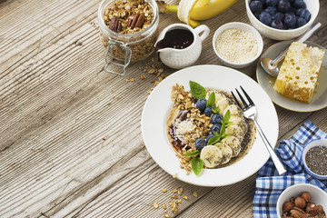 Healthy breakfast trend. Thin oat pancakes with banana, blueberries, goji berries, sesame and chia seeds