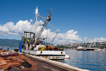 spread fishing nets, fishing boat on dock in port of Rijeka, Croatia
