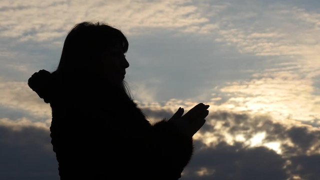 silhouette of praying woman with beautiful sky background