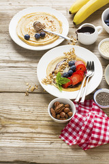 Oatmeal pancakes in a frying pan on wooden table