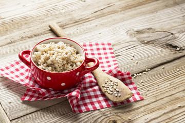 The red ceramic saucepan with white polka dots complete crumbly barley porridge