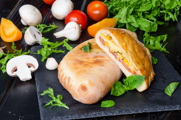 Calzone pizza with ham , mushrooms and corn