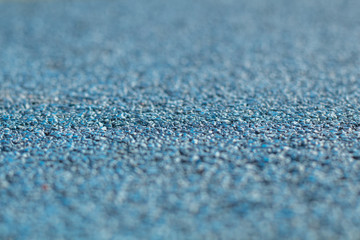 Colorful blue Rubber Wetpour playground floor surface, shot low down with narrow depth of field.