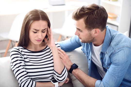 Sad Sick Woman Sitting On The Couch With Her Boyfriend