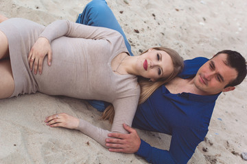 Fototapeta premium Man and pregnant woman are resting on the beach
