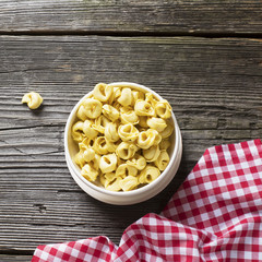 White ceramic bowl full of Italian pasta tortellini to cooking