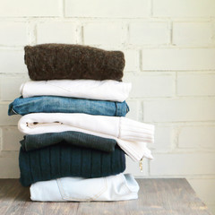 Denim and cotton clothes stacked On a wooden surface