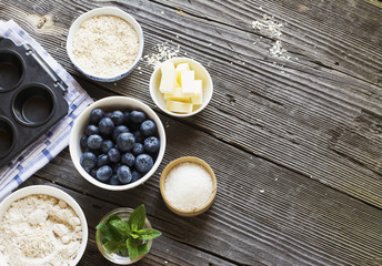 Healthy homemade cakes. Ingredients for blueberry muffins on a dark wooden background