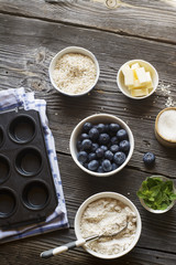 Healthy homemade cakes. Ingredients for blueberry muffins on a dark wooden background