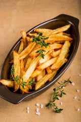 Potatoes fries in the bowl with salt and thyme