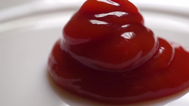 Putting ketchup on a white plate